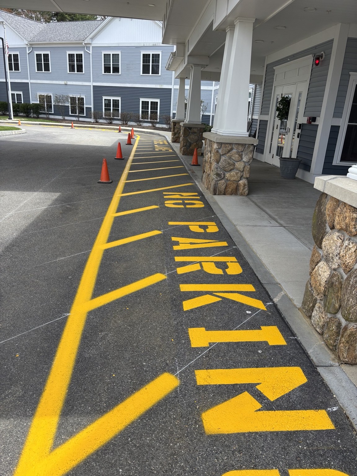 Yellow no parking fire lane lettering beside a building